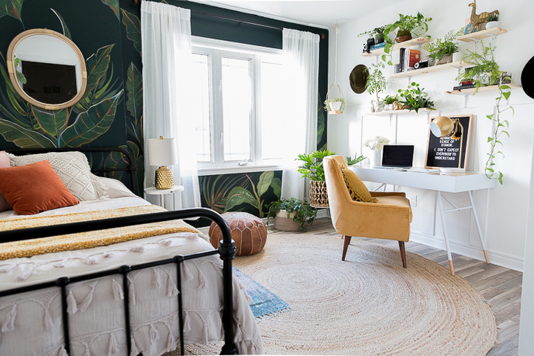 Midcentury modern bohemian bedroom with yellow chair and palm leaf wall mural