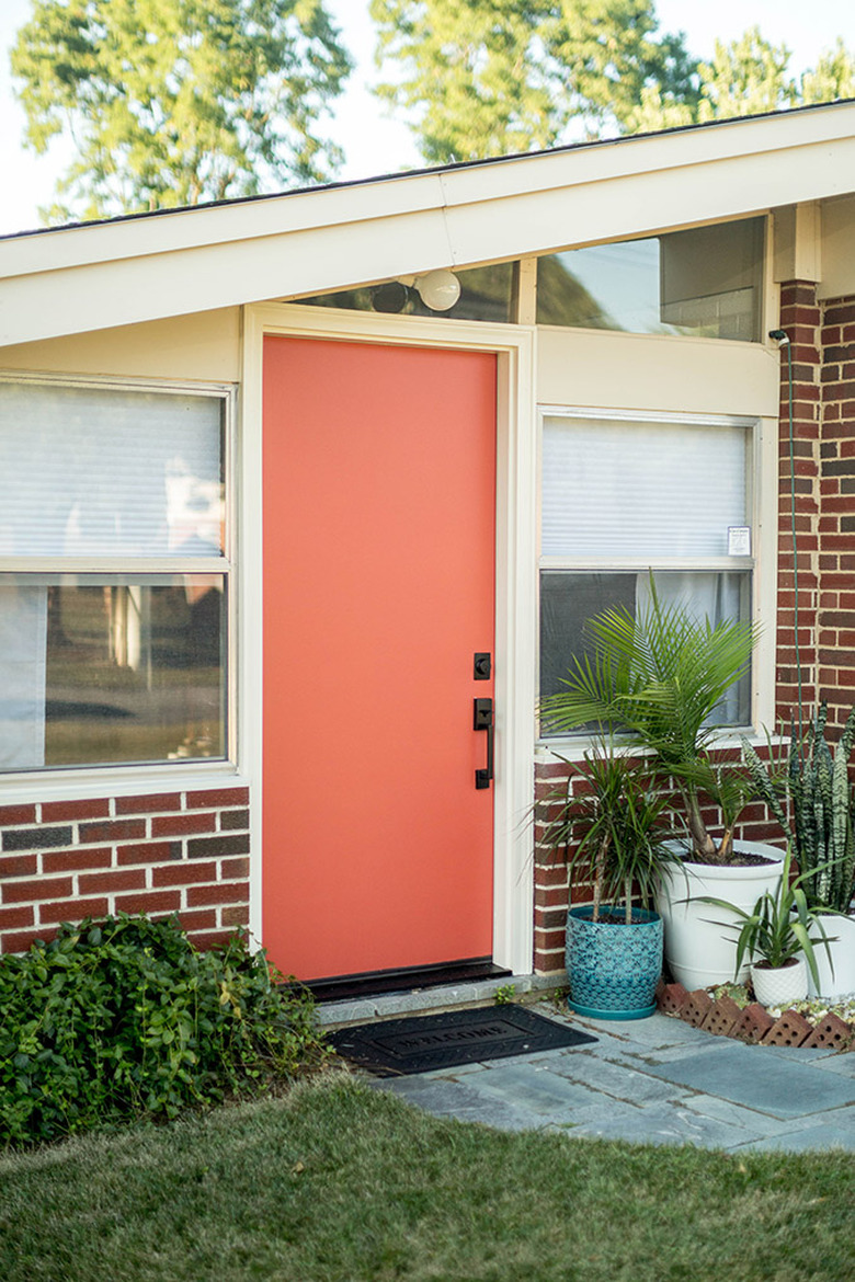 coral midcentury modern front door with brick exterior