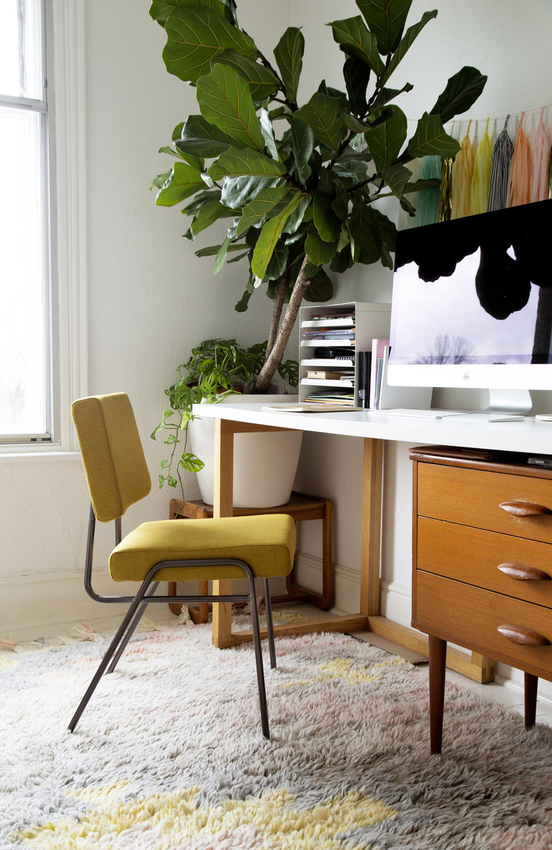 Midcentury modern home office with vintage yellow chair and fiddle leaf fig