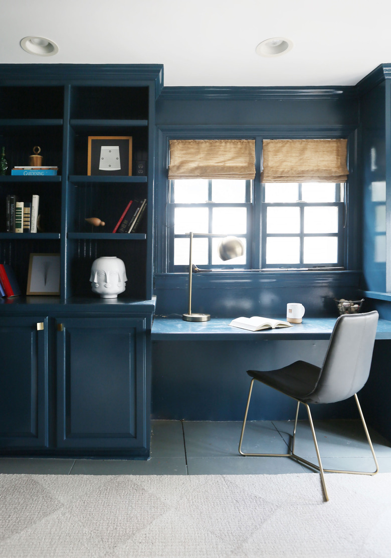 Midcentury modern home office in navy blue with built-in displaying decor