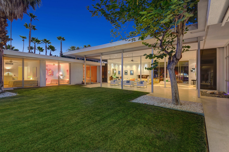 outdoor area of house with tree and large glass windows