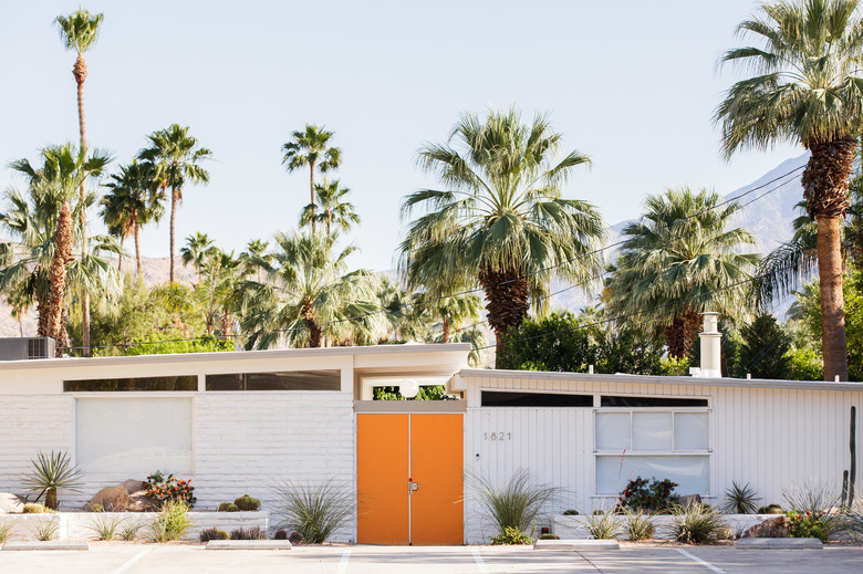 white midcentury-modern home in palm springs with palm trees