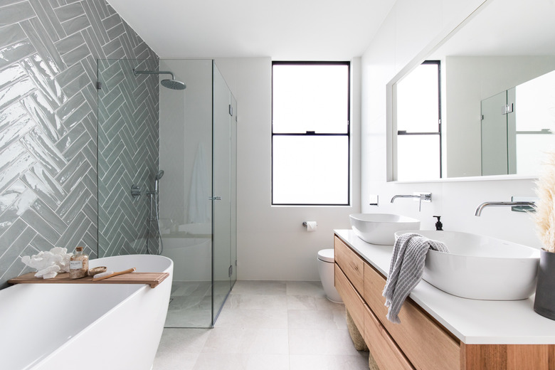 minimalist bathroom vanity with two bowl sinks in in bathroom with herringbone tile