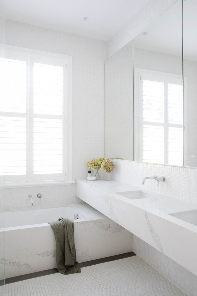 minimalist bathroom vanity with marble counter and tub