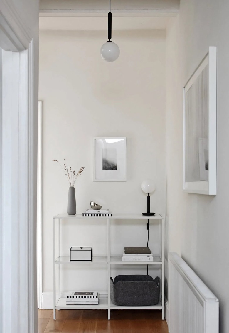 minimalist hallway with hanging light and framed artwork