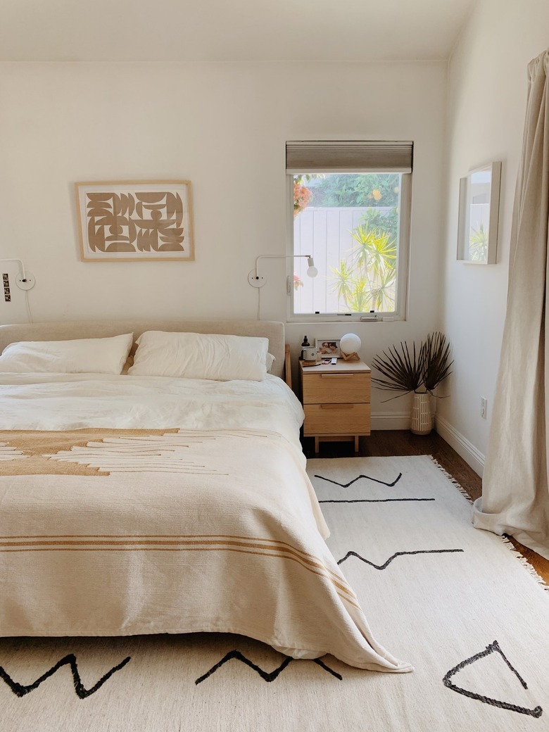 minimalist bedroom with geometric area rug and white walls