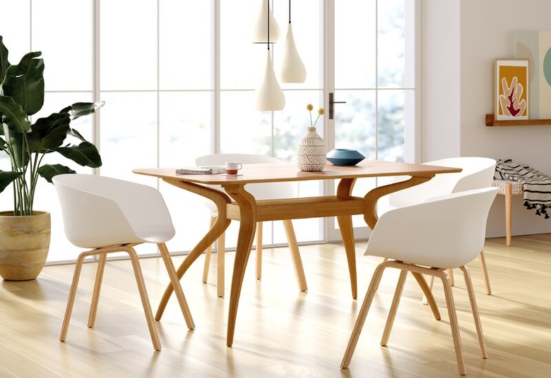 Minimalist dining room idea with midcentury wood table and white chairs with pendant lighting above