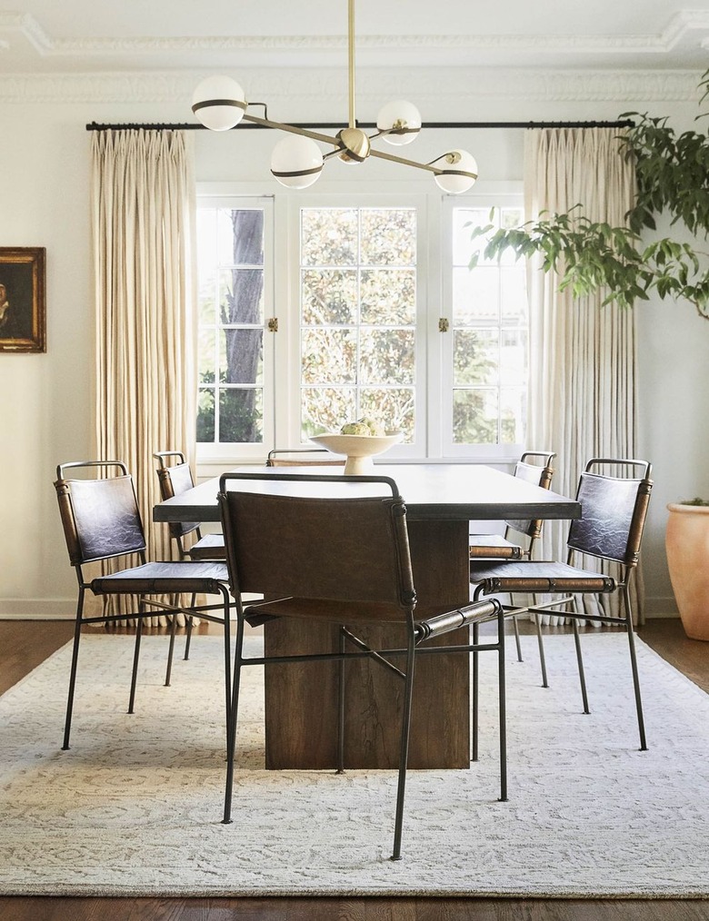 Minimalist dining room idea with industrial-chic dining chair with wood table below modern chandelier