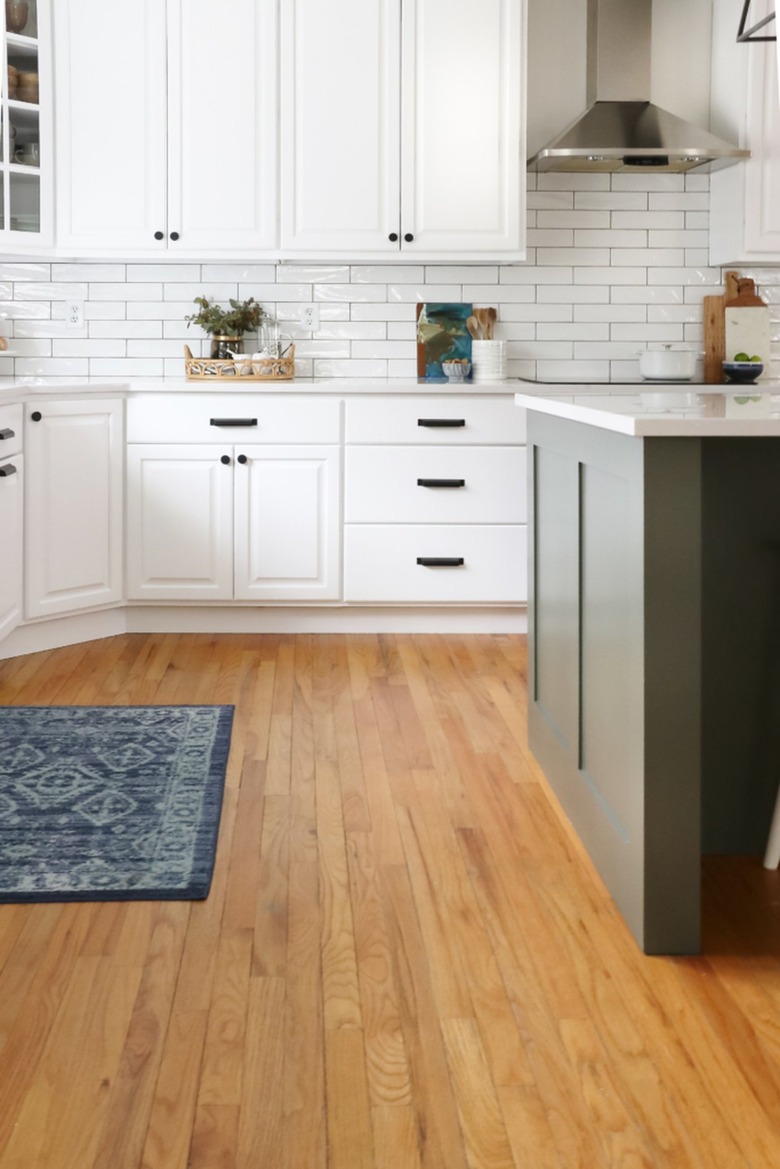 white farmhouse kitchen with white cabinets and green island