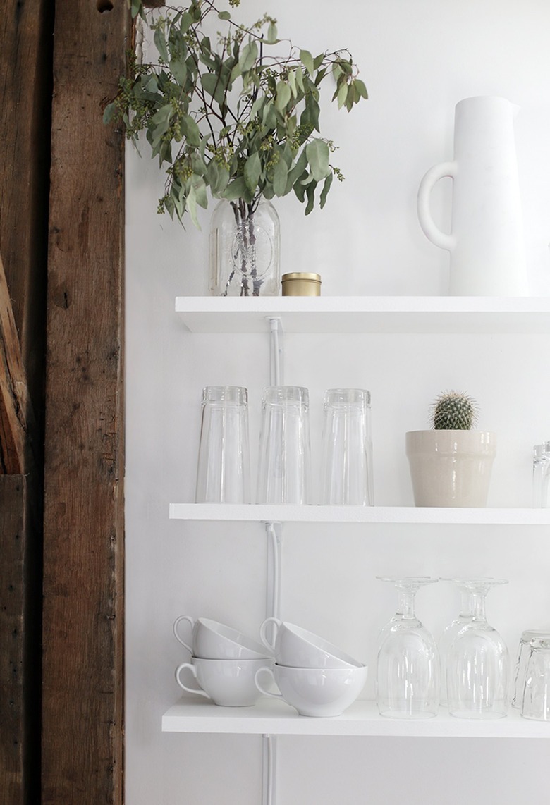 white kitchen with white and clear glassware on open shelves