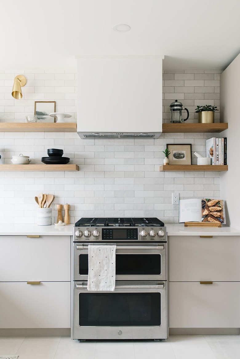 white kitchen with subway tile backsplash and stainless steel stove