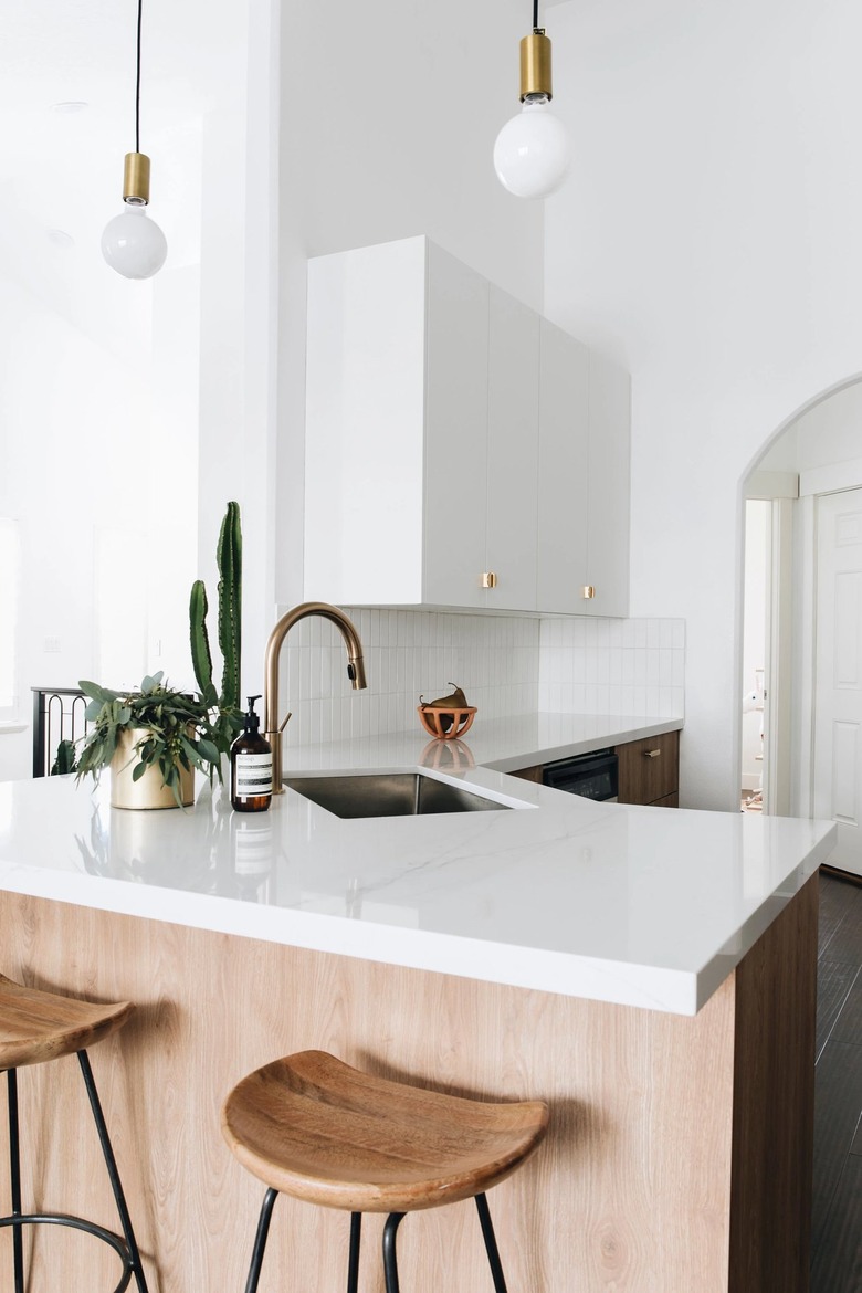 modern white kitchen with glossy white countertop and pendant lights