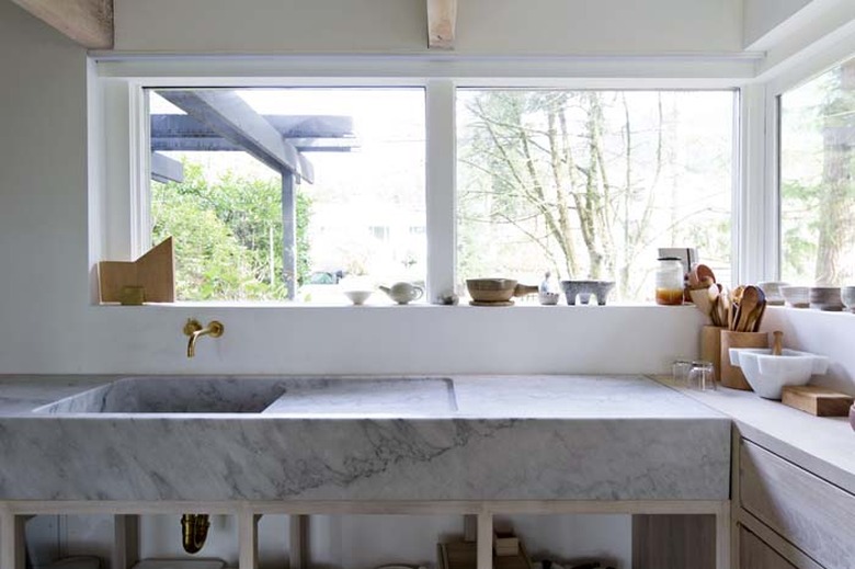 Marble minimalist kitchen sink with wall-mounted brass faucet