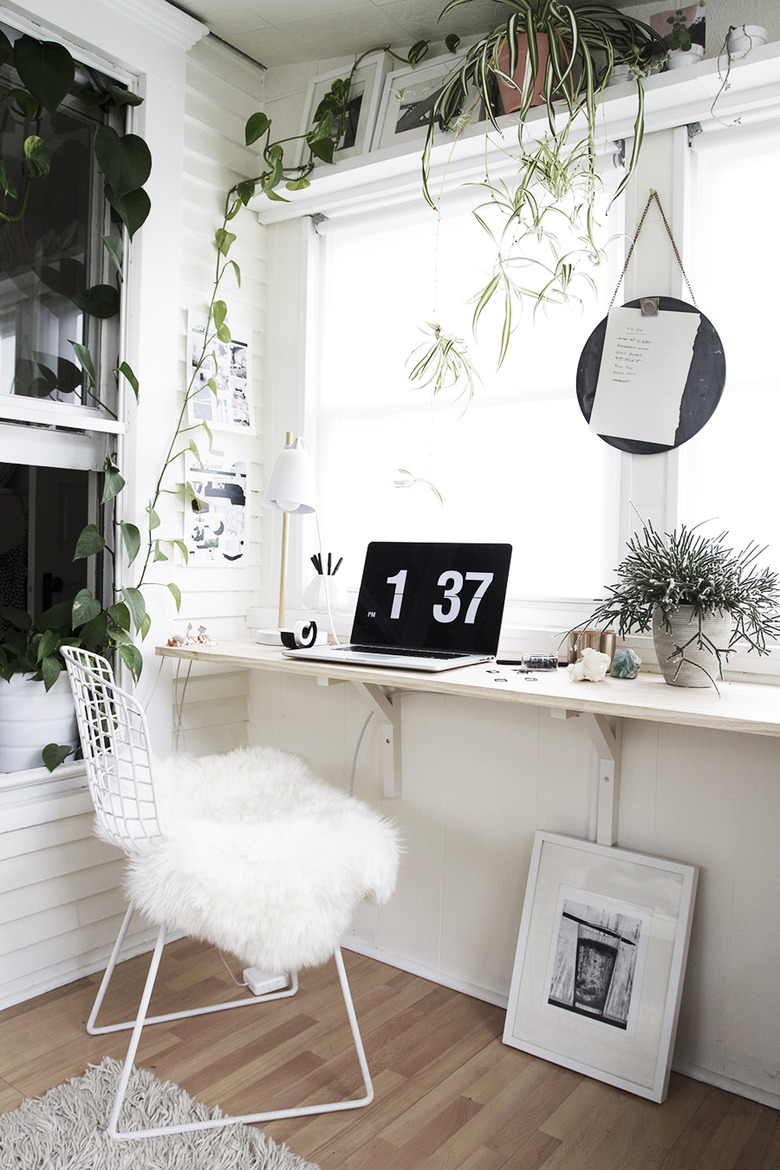 minimalist modern home office design with floating desk and plants