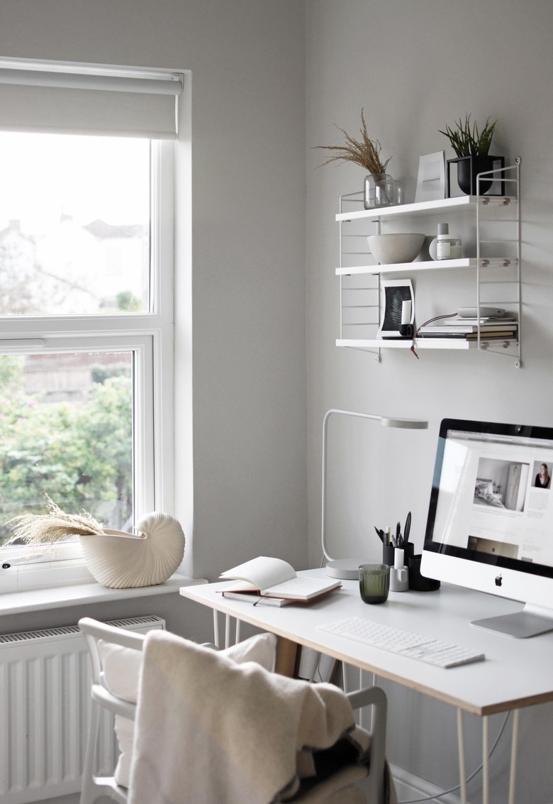 minimalist modern home office design with open shelving and gray walls