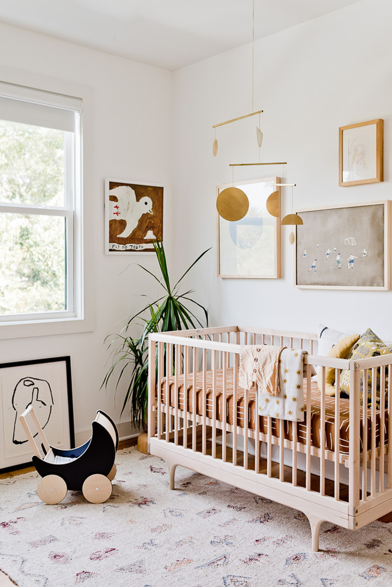 white minimalist nursery decor with wood crib and rug