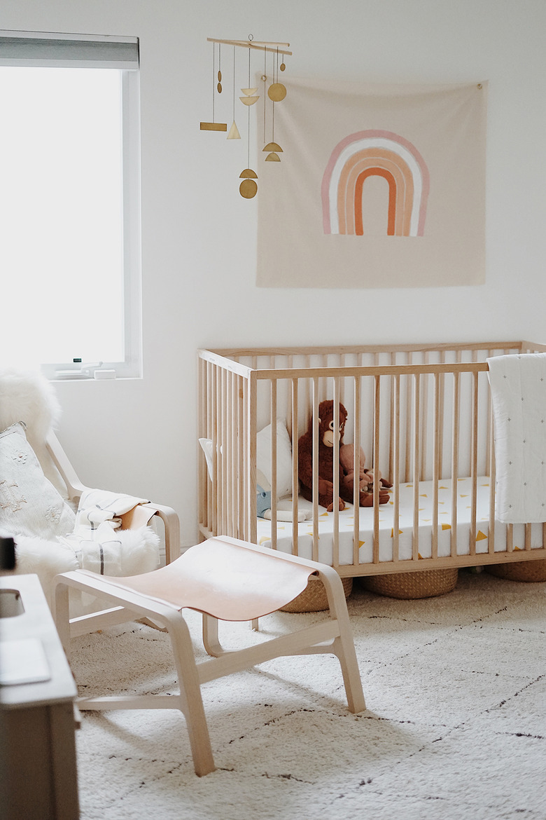 white minimalist nursery decor with crib and hanging art