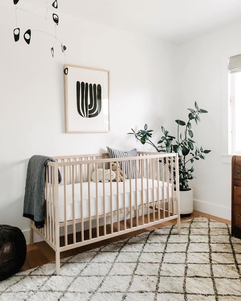 white minimalist nursery decor with plant in the corner