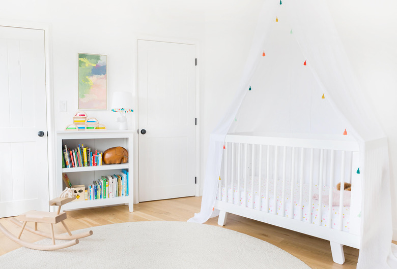 all-white minimalist nursery decor with crib canopy