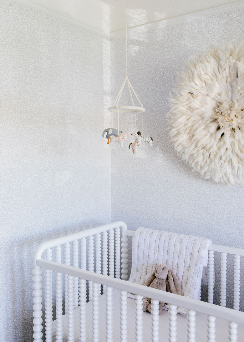 white minimalist nursery decor with white crib and wall art