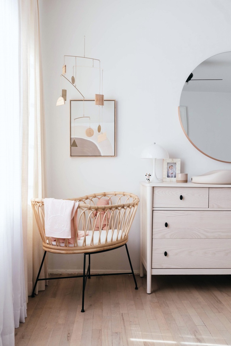 white minimalist nursery decor with bassinet in the corner