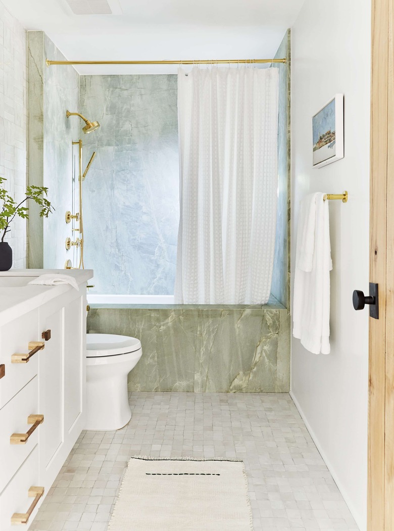 minimalist shower with green stone bath and white vanity in a white room