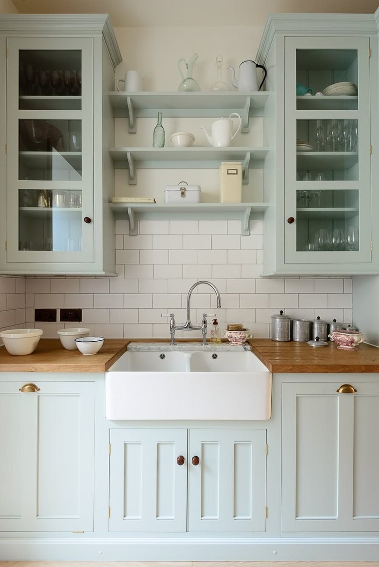 farmhouse kitchen with butcher block counters and a farmhouse sink, mint green cabinets