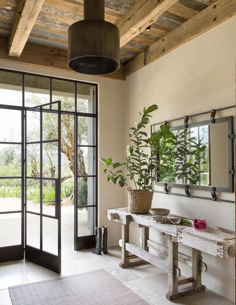 Rustic foyer with industrial-inspired mirror