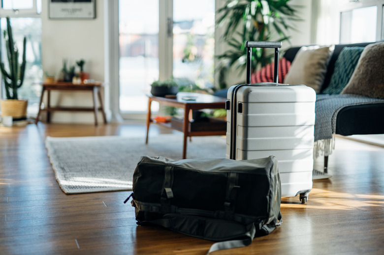 Still-life of suitcase and carry bag, on the floor of cool holiday apartment