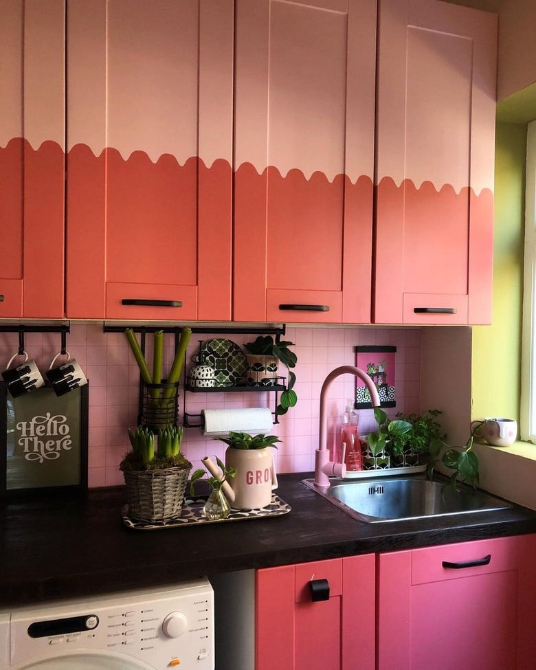 kitchen with pink and salmon cabinets and faucet and plants