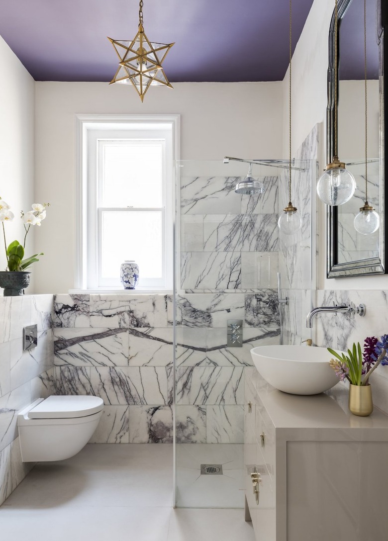 purple bathroom with marble clad wall