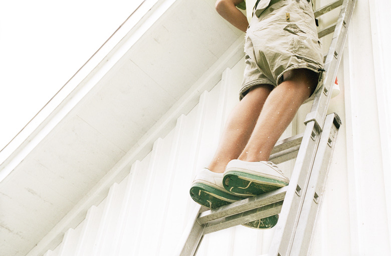 Man standing on ladder, low angle view