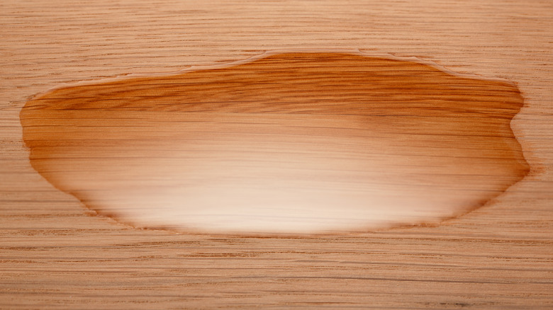 Closeup of oil on a wooden surface. Selective focus.