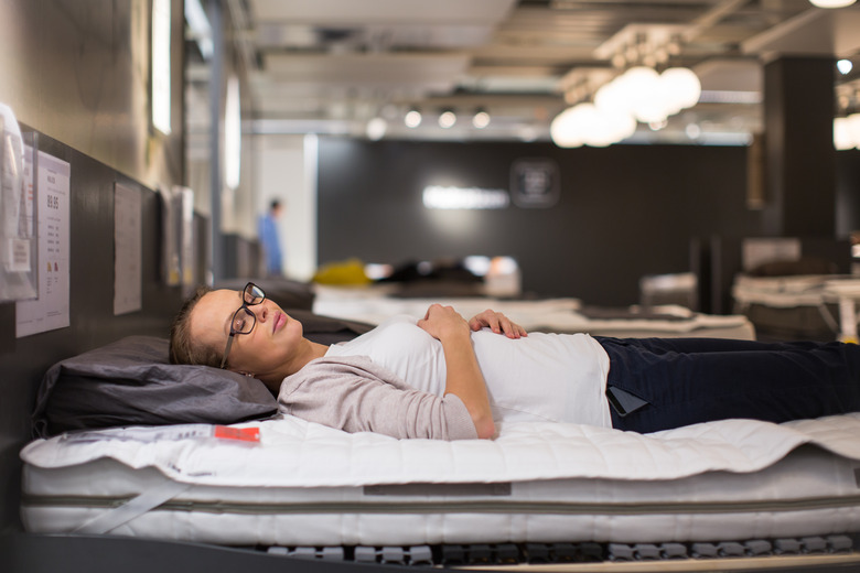 Pretty, young woman choosing the right furniture for her apartment