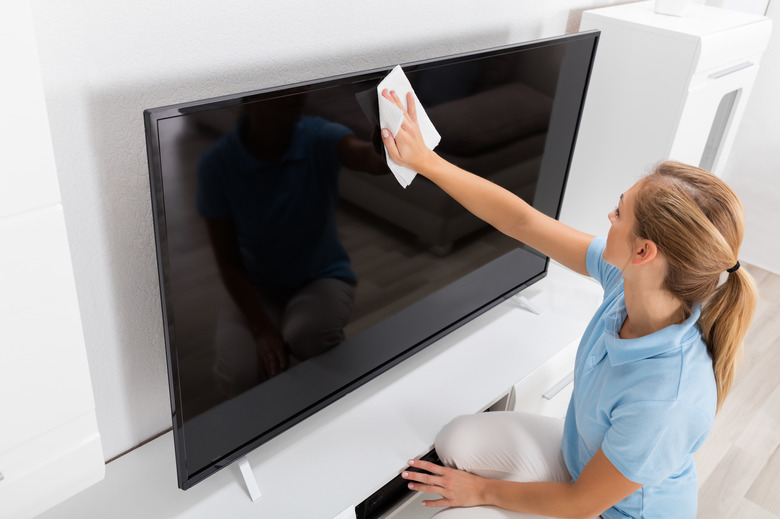 Woman Cleaning TV Screen