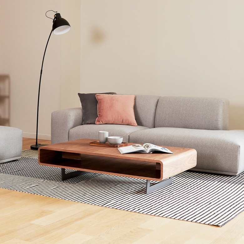 Low rectangular rounded coffee table with one wide open shelve and low metal legs