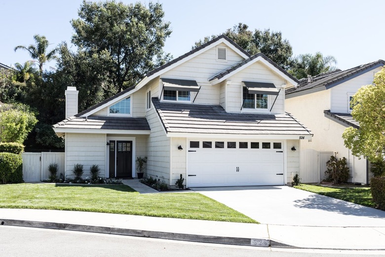 A white suburban house with a small patch of green grass