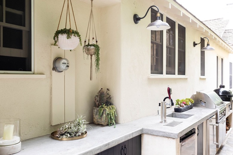 outdoor kitchen with hanging plants and stone countertop