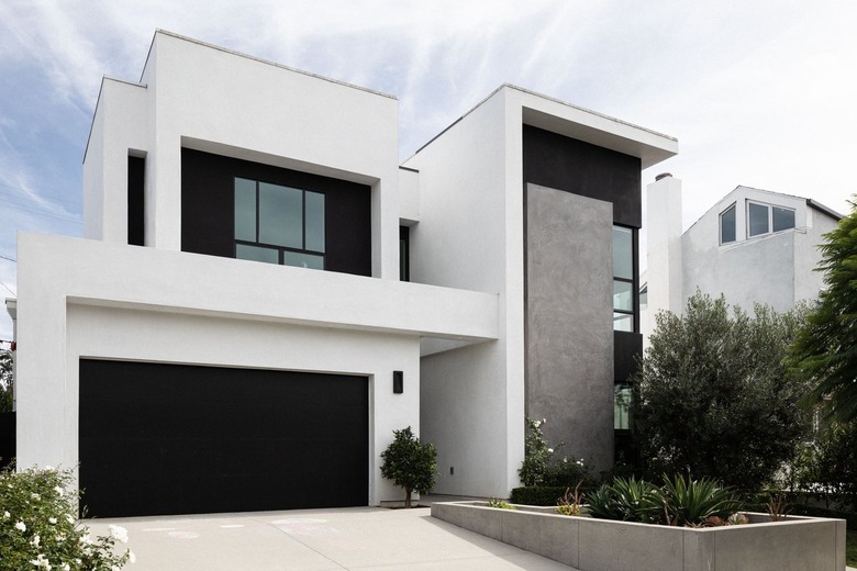 Black and white minimalist-modern house with black garage door