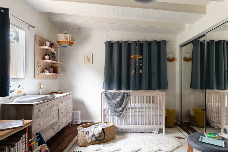 A nursery with blue curtains and beige furnishings