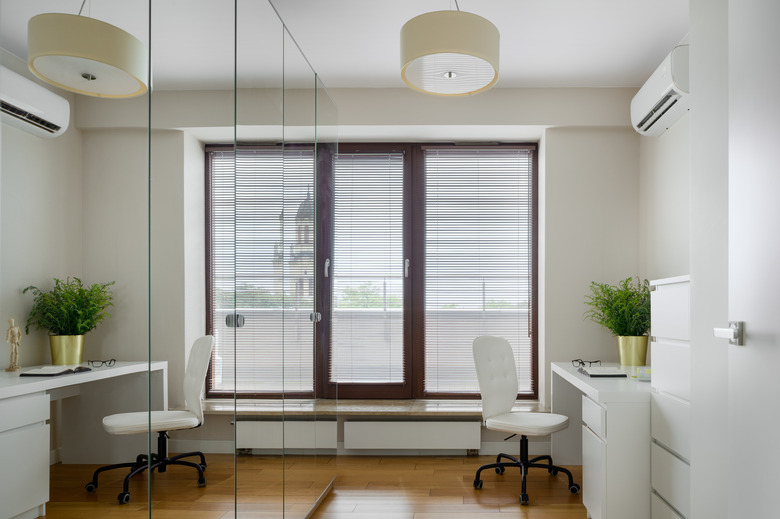 Home office with mirrored wardrobe and mini blinds on window and door.