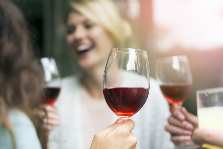 Wineglass held by woman during social gathering