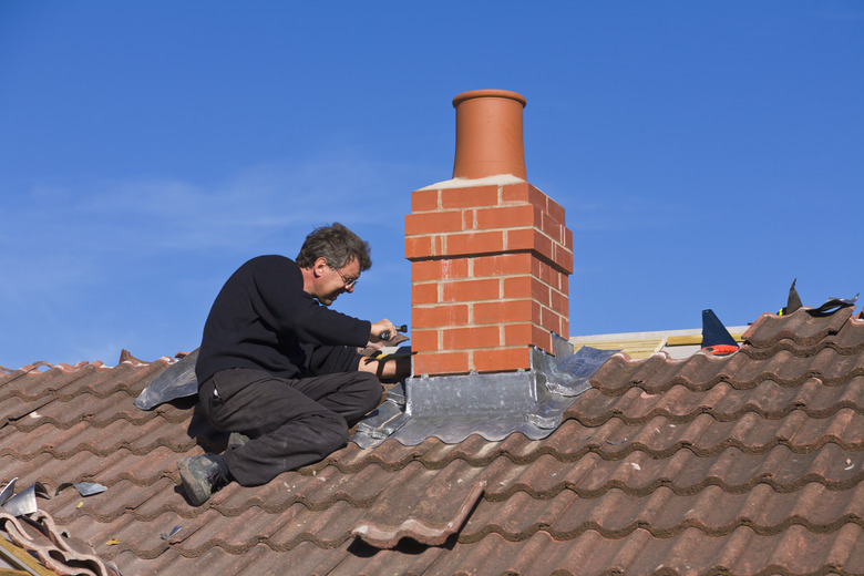 Installing flashing around chimney stack.