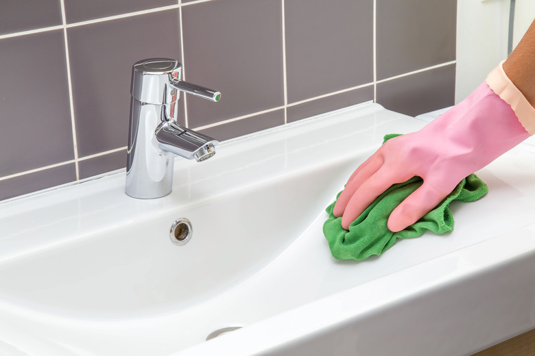 In the bathroom, ceramic sink, tiles and water tap washing.