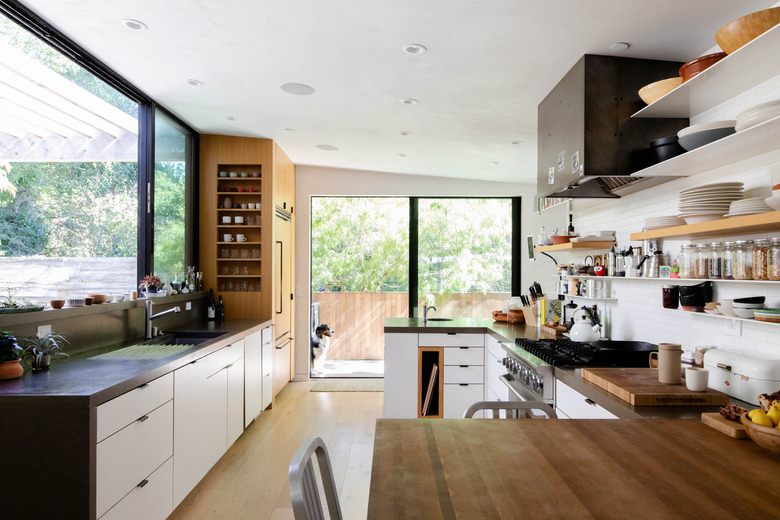 large galley kitchen with oversized windows and sliding doors leading out to backyard