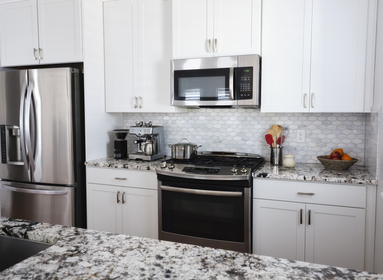 Modern kitchen with shiny stainless steel appliances.