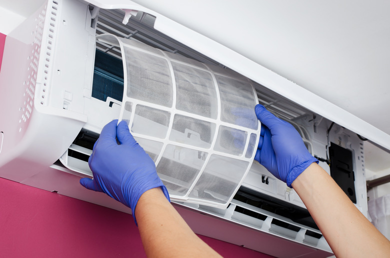 Air conditioner cleaning. Man checks the filter.