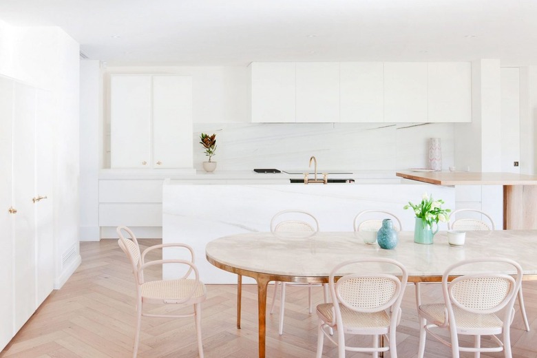 white kitchen with chevron wood flooring