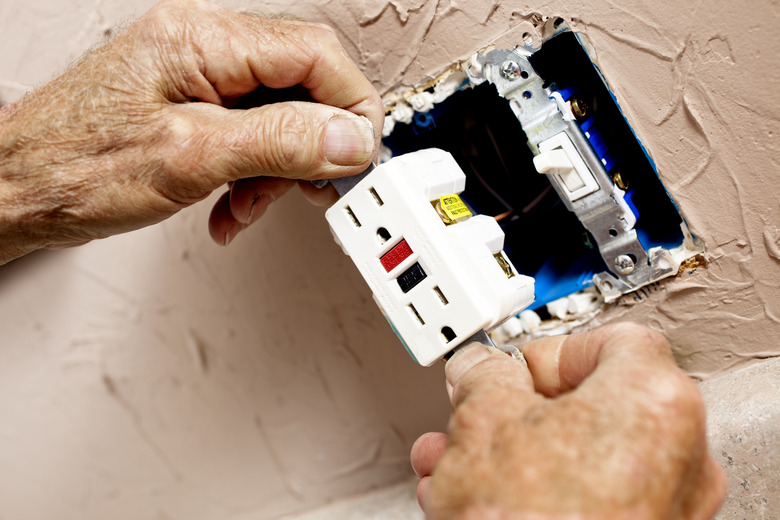 Electrician installing a plug in kitchen.