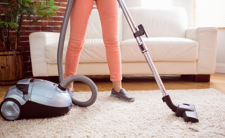 Woman hoovering the rug